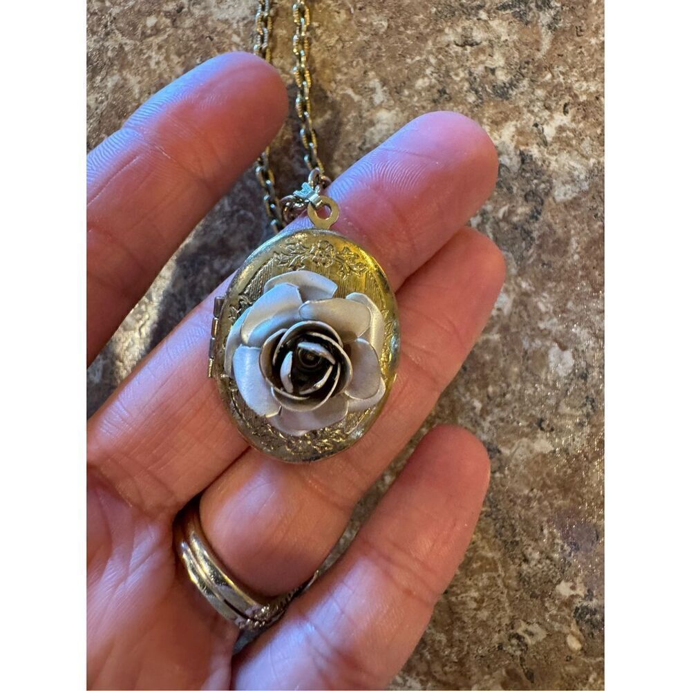 Woman’s vintage locket necklace with rose on it